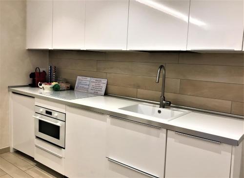 a kitchen with white cabinets and a sink at Valpolicella Hills in Negrar
