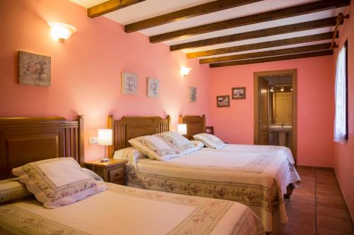 2 camas en una habitación con paredes rosas en Casa Rural Toki Ona II en Valcarlos
