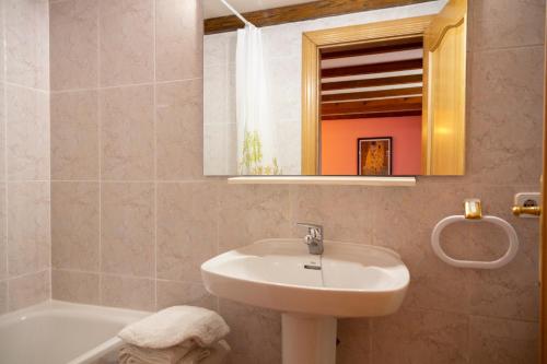 a bathroom with a sink and a mirror and a tub at Casa Rural Toki Ona II in Valcarlos