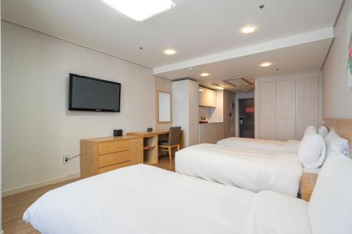 a hotel room with two beds and a flat screen tv at Ramada by Wyndham Seoul Dongdaemun in Seoul