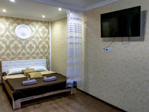 um quarto com uma cama e uma televisão de ecrã plano em Soborna 31 em Kamianets-Podilskyi