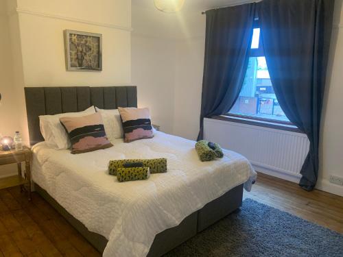 1 dormitorio con cama con almohadas y ventana en Laura Ashley cosy inner terrace en Barnsley