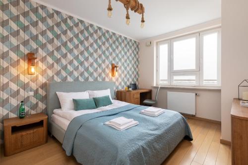 ein Schlafzimmer mit einem Bett mit zwei Handtüchern darauf in der Unterkunft Rent like home - Słomińskiego 5 II in Warschau