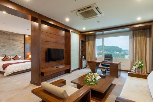 a hotel room with a bed and a desk and a television at Lao Cai Star Hotel in Lao Cai