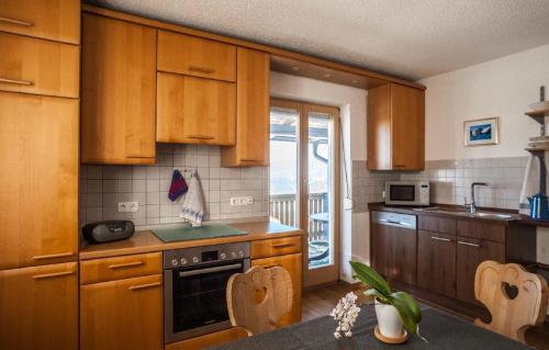 eine Küche mit Holzschränken und einem Tisch mit Stühlen in der Unterkunft Ferienwohnung Sigi's Waldhaus in Neuschönau