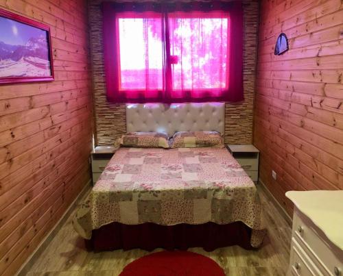 アグアス・デ・サン・ペドロにあるSwiss Chaletのベッドルーム1室(ピンクの窓、ベッド1台付)