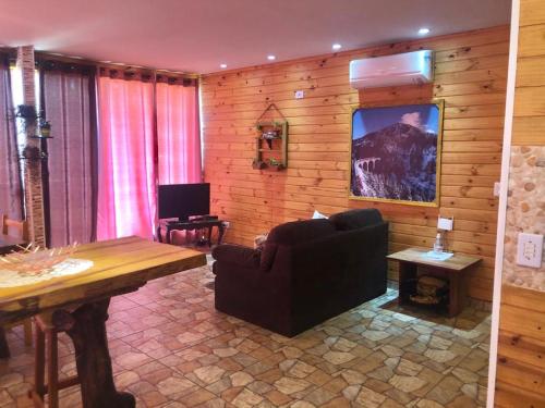 a living room with a couch and a table at Swiss Chalet in Águas de São Pedro