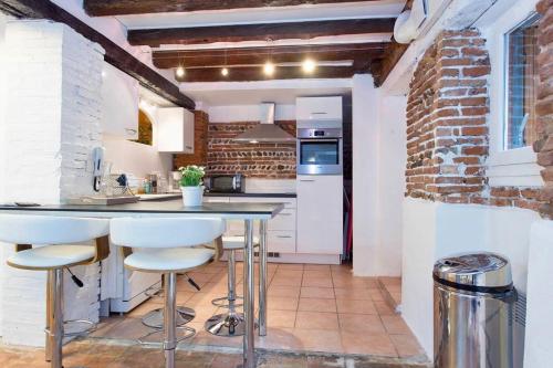 une cuisine avec un comptoir et des tabourets dans une pièce dans l'établissement L' Appart, à Toulouse