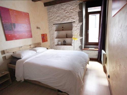 Le Thiou Paradise Annecy في أنِسي: غرفة نوم بسرير ابيض ونافذة