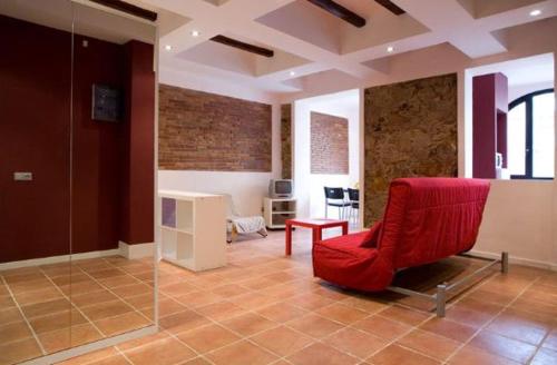 a living room with a red chair and a table at Sunny Apartments Barcelona in Barcelona