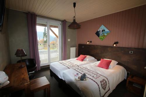 um quarto com uma cama grande e almofadas vermelhas em Les Loges Du Parc em Gérardmer