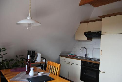 eine kleine Küche mit einem Holztisch und einem weißen Kühlschrank in der Unterkunft Ferienwohnung Stricker Typ A, Balkon 2/3 in Walkenried