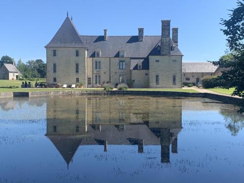 un gran castillo sobre un cuerpo de agua en Manoir de Cléronde - B&B en Blay