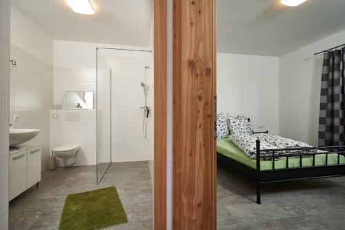 a bedroom with a bed and a bathroom with a sink at Arche Ötztal in Umhausen