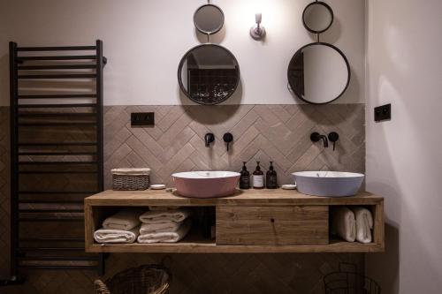 a bathroom with two sinks and mirrors on the wall at Chalet SALAMANDRA in Banská Štiavnica