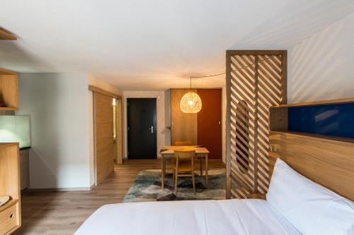ein Hotelzimmer mit einem Bett und einem Tisch in der Unterkunft GAMA Home in Freiburg im Üechtland