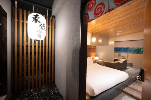 a bedroom with a white bed and a desk in a room at Yunoyado Onsen Hot Spring Hotel Deyang in Jiaoxi
