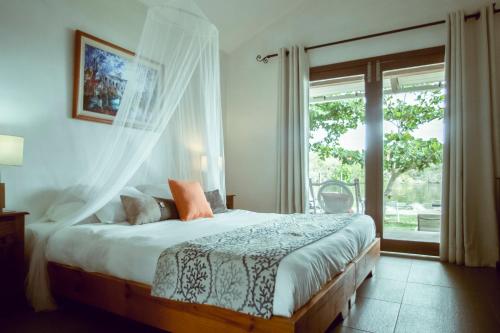 a bedroom with a large bed with a window at The River House in Tamarin
