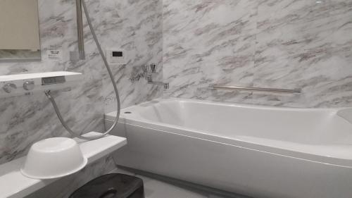baño con bañera blanca y aseo blanco en Mon Petit Chat en Kanazawa
