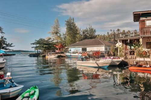 einer Gruppe von Booten, die in einem Wasserkörper angedockt sind in der Unterkunft Baan Rabieng Talay Homestayบ้านระเบียงทะเล โฮมสเตย์เกาะกูด in Ko Kood