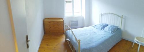 a bedroom with a bed and a dresser and a window at la violette in Ferrières-Saint-Mary