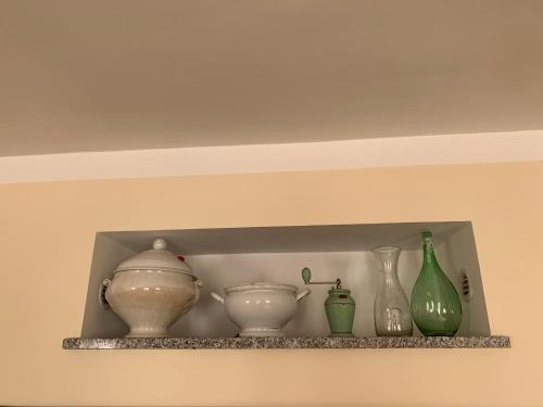 a shelf with vases and bowls on it at Agriturismo Cascina Mariale in Albiano dʼIvrea