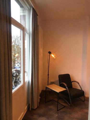 a chair and a table in front of a window at Brussel House Basilic in Brussels