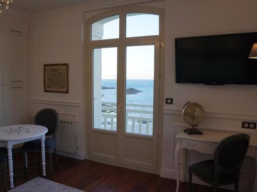 een kamer met een raam en een deur met uitzicht op de oceaan bij Villa Ker Eole Vue Mer in Dinard