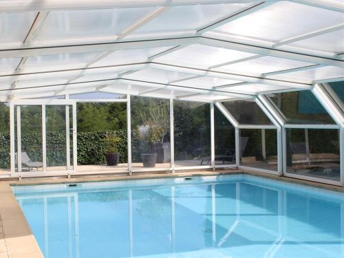 an aluminum pool house with awning and a swimming pool at Chambre D'hôte La Beaudine in Forcalquier