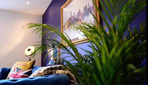 a living room with a blue couch and a plant at 4 Bedroom House - DISC0UNTS - Parking, Contractors, Group, Family in Canterbury
