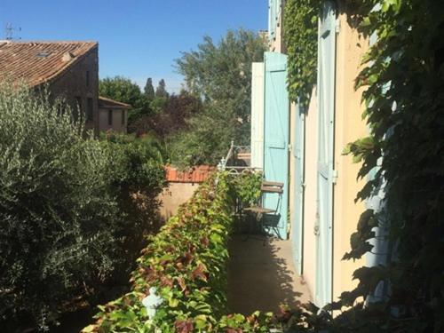 a small canal next to a building and a house at Le Jardin d'Homps in Homps