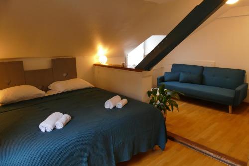 a bedroom with a bed and a blue couch at Villa Rosa Trois Epis in Trois-Épis