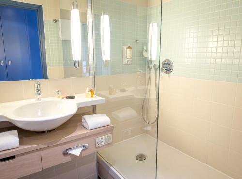 a bathroom with a sink and a shower at Mercure Chantilly Resort & Conventions in Chantilly