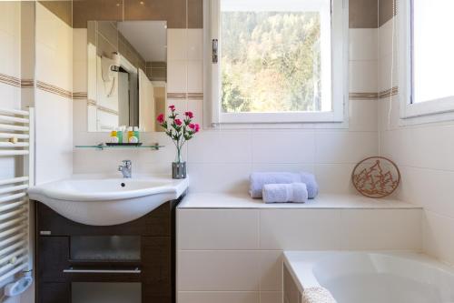 un bagno bianco con lavandino e finestra di Chalet Hôtel La Sapinière a Chamonix-Mont-Blanc