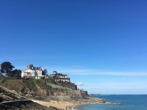 uma casa no topo de uma colina junto ao oceano em Villa XIXe Vue mer em Dinard