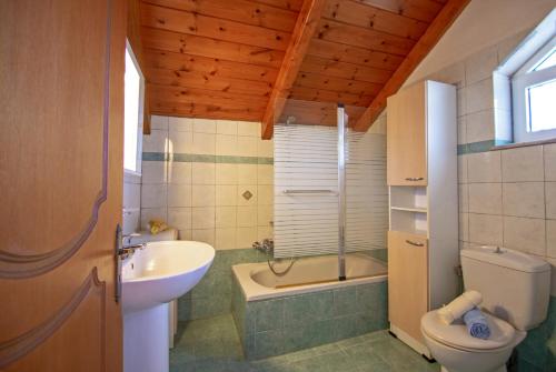 a bathroom with a sink and a toilet and a tub at Psarou Studios in Amoudi