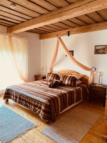 a bedroom with a bed with a wooden ceiling at Marcienas Muiza & SPA in Mārciena