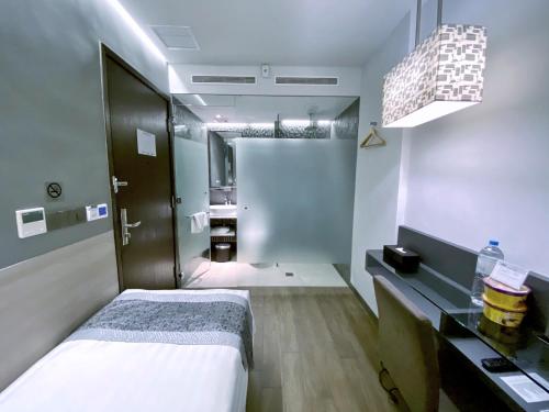 a small room with a bed and a bathroom at Bliss Hotel Singapore in Singapore