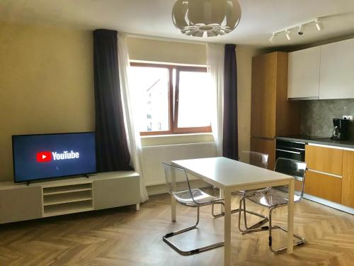 un salon avec une table et une télévision dans l'établissement Cozy Modern One Bedroom, à Floreşti
