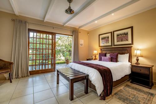 een slaapkamer met een groot bed en een raam bij Country Lane Lodge in White River