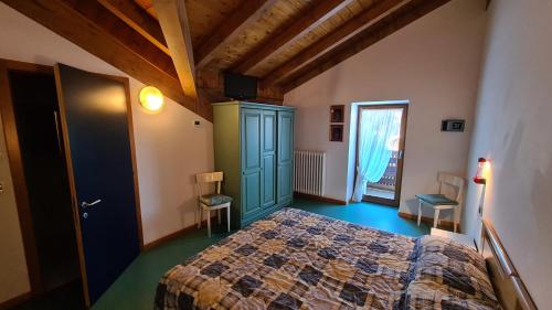 1 dormitorio con 1 cama en una habitación con ventana en Hotel Martinella, en Folgaria