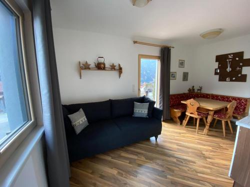 - un salon avec un canapé bleu et une table dans l'établissement Appartement Klein Tirol, à Pettneu am Arlberg