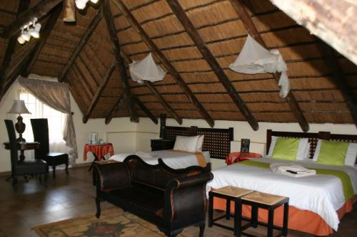 una camera con due letti e una sedia in una stanza di Villa Royal Palm a Komatipoort