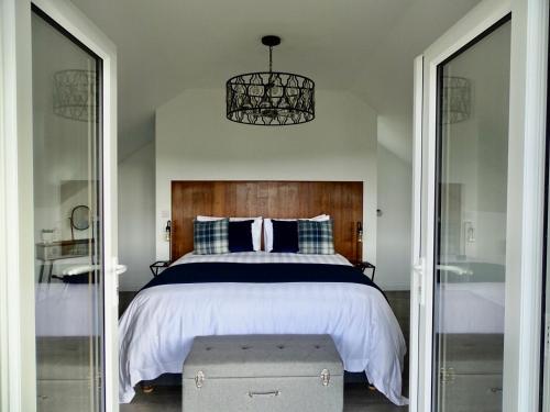 a bedroom with a large bed with a wooden headboard at The Kite, Upper Torrs View in Ilfracombe