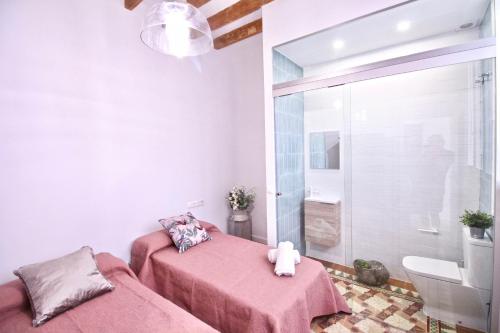 アリカンテにあるApartamento Grande y Luminoso en el Centro de Alicanteのピンクのシーツが備わるベッドルームのベッド2台