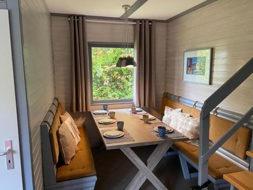 a dining room with a table and benches and a window at Haus Elise in Kirchheim