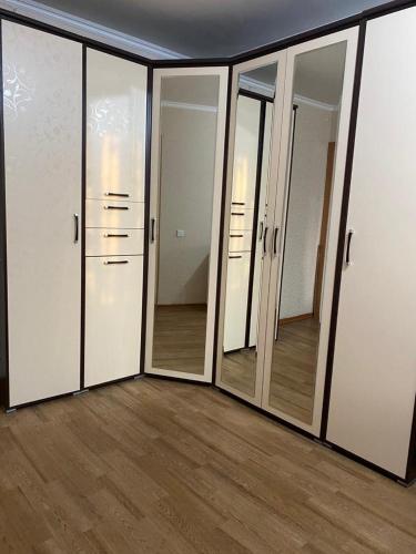 um quarto com um monte de portas e espelhos em Домашний уют em Karaganda