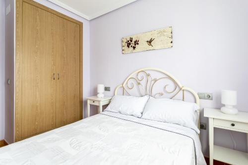 Un dormitorio con una cama blanca y una puerta de madera. en VdC Bungalow near San Juan Beach, en San Juan de Alicante