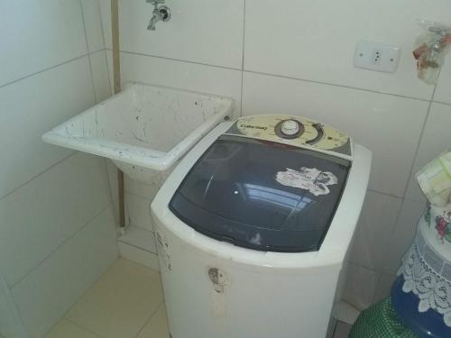 a small bathroom with a toilet and a sink at Apartamento à 50 metros da praia - Itanhaém in Itanhaém