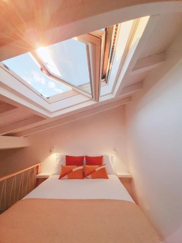 a bedroom with a bed with red pillows and a window at Casa Vinte & Cinco Alojamento Local in Penha Garcia